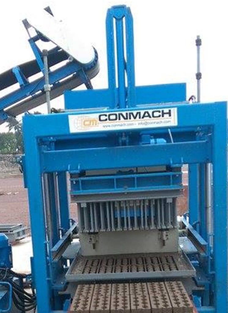 Mavi boyalı, ağır çelik konstrüksiyondan oluşan bir beton blok makinesinin montaj aşamasındaki boş iskeleti ve iç mekanizması. Makinenin üst kısmında baskı kafası ve alt kısmında palet taşıma rayları detaylıca görülmektedir.